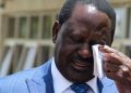 Raila Odinga wiping tears from his eyes.
