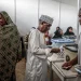 A voter prepares to cast his ballot while others queue at the Maundi voting centre in Stone Town on October 29, 2025, during Tanzania's presidential elections.