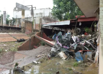 Stacked school desks at a damaged school after torrential rains that overflowed rivers, causing flooding