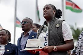 Winnie Odinga carries his father's iconic white hat while exiting the plane at JKIA