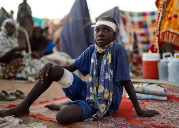 A boy sits at a camp for displaced people who fled from el-Fasher to Tawila, North Darfur, on October 27, 2025