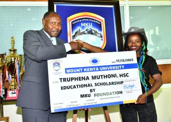 Truphena Muthoni being awarded full academic scholarship by Professor Peter Wanderi